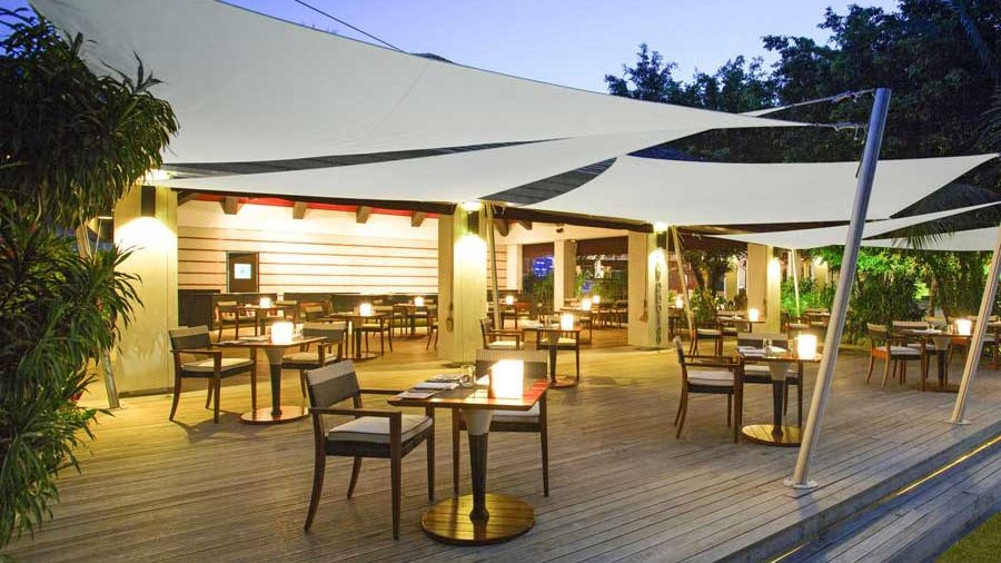 Toldos de vela iluminados sobre la terraza de un establecimiento de hostelería