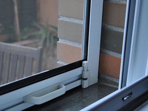 Mosquitera fija instalada de forma permanente sobre un hueco de ventana