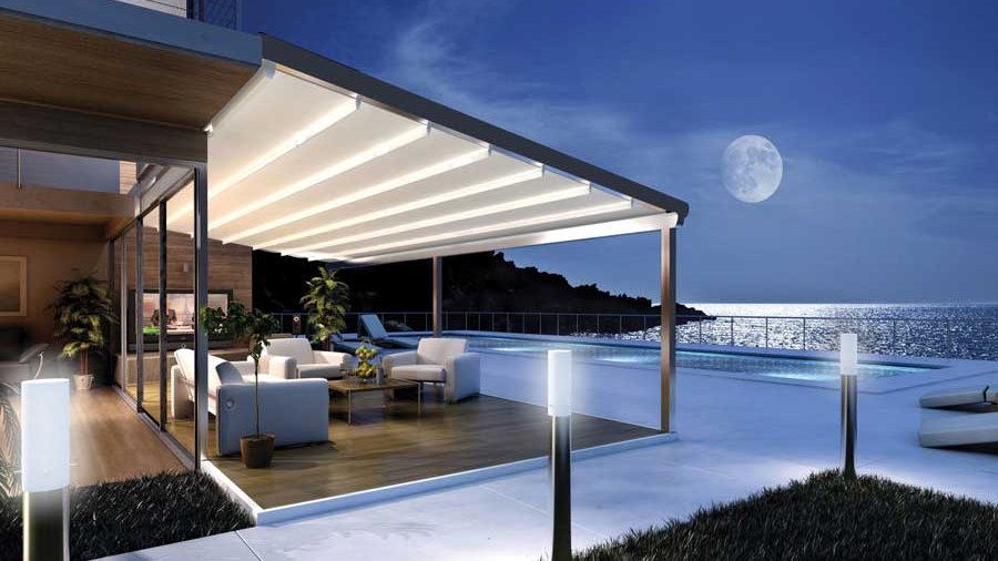 Pérgola retráctil de estructura blanca sobre una terraza junto a una piscina