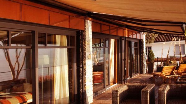 Toldo de brazos articulados extendido sobre la terraza de una vivienda