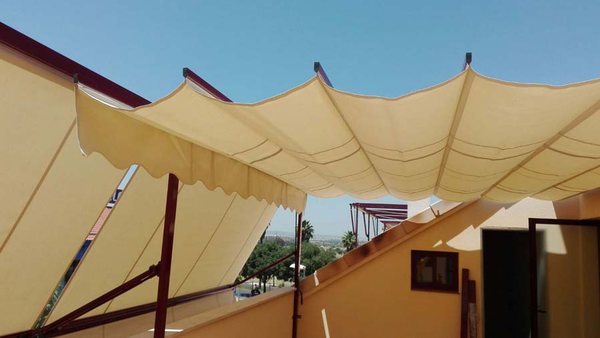 Pérgola con cubierta textil instalada sobre un jardín